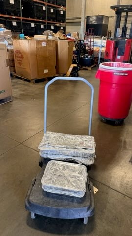 Foil trays of home-cooked meals on a cart in a warehouse