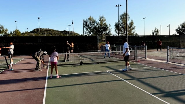 Community members playing pickleball at an outdoor clinic