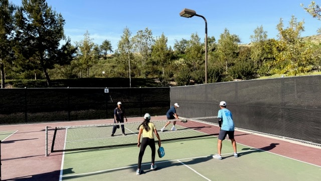 Community members gathered on the pickleball court during a clinic