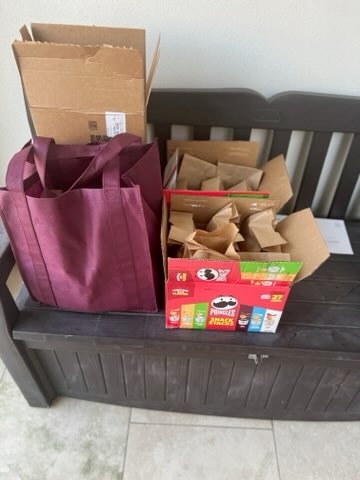 Donation bags and supplies including purple tote and Pringles